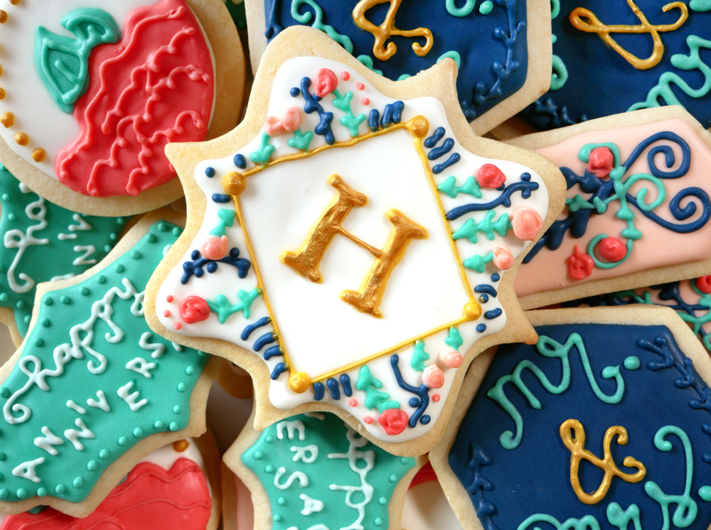 Royal icing decorated cookies - sugar cookies decorated with blue, pink, and gold royal icing for a monogram anniversary gift.