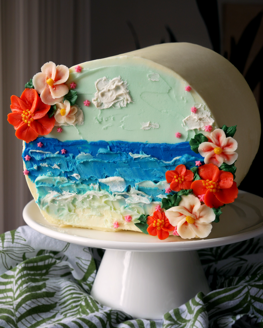 This Hawaiian beach and buttercream flower cake is painted with palette knives and decorated sideways as a sideways cake top forward design!